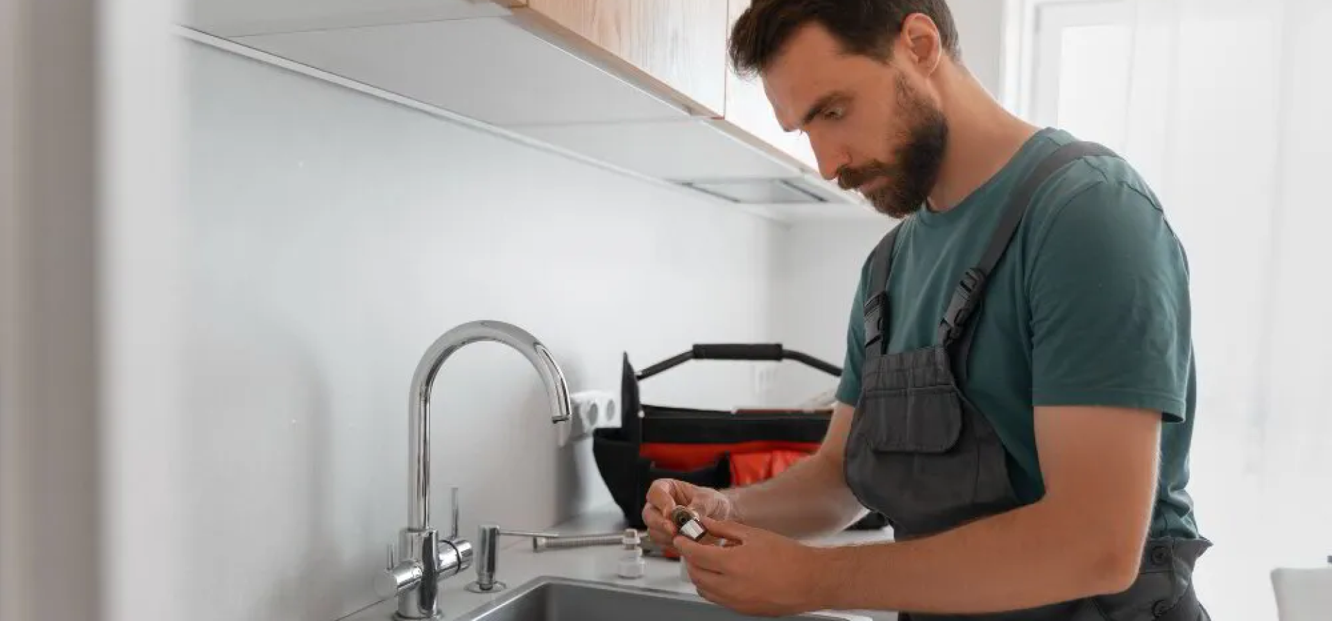 Professional plumber working on a sink installation